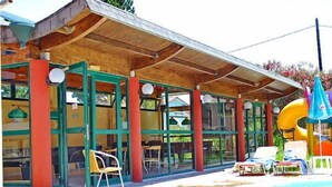 Un espacio exterior cubierto con piscina, sillas de descanso y un tobogán.