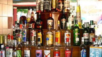 Un bar con una variedad de botellas de licor y vasos.