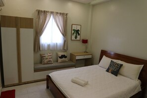 Un dormitorio con cama, mesita de noche, lámpara, ventana con cortinas, armario y un cuadro colgado en la pared.