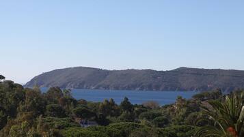 A coastal landscape with a view of the sea and hills.