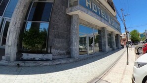 Un hotel amb façana moderna, grans finestres i una entrada destacada.