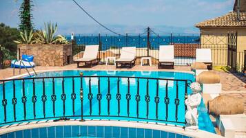 Relax by the serene pool surrounded by lounge chairs and lush greenery.