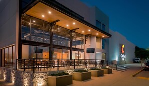 A Comfort Inn hotel with a covered outdoor seating area, large windows, and a stone facade. - Comfort Inn Hermosillo Pitic (Hermosillo)