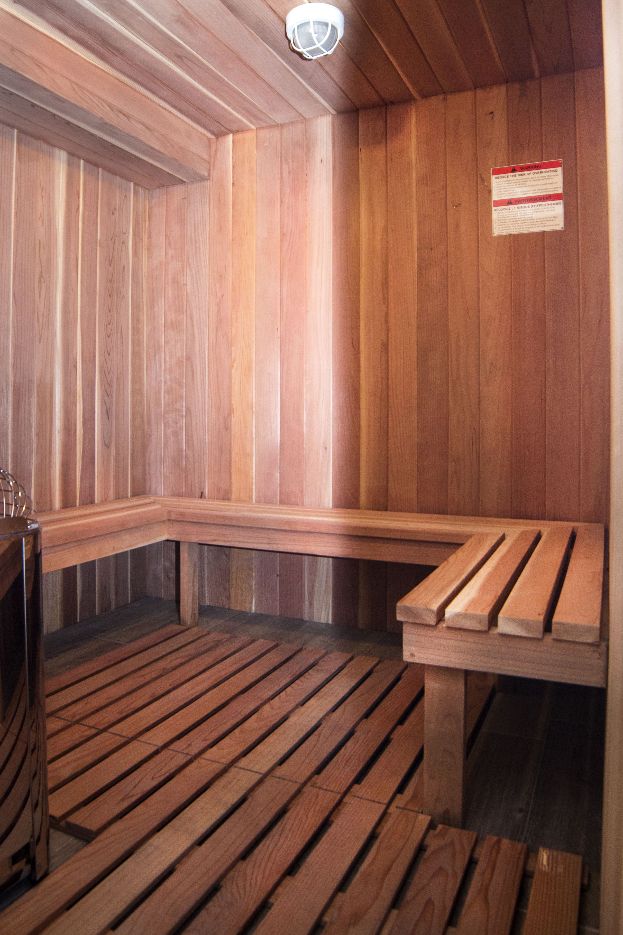 A sauna with wooden benches and a sign on the wall.
