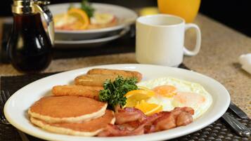 A breakfast plate with pancakes, bacon, eggs, and toast.