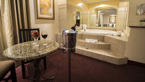 A hotel bathroom with a marble sink, a bathtub, and a marble table with wine glasses. - Hotel Ticuán (Tijuana)