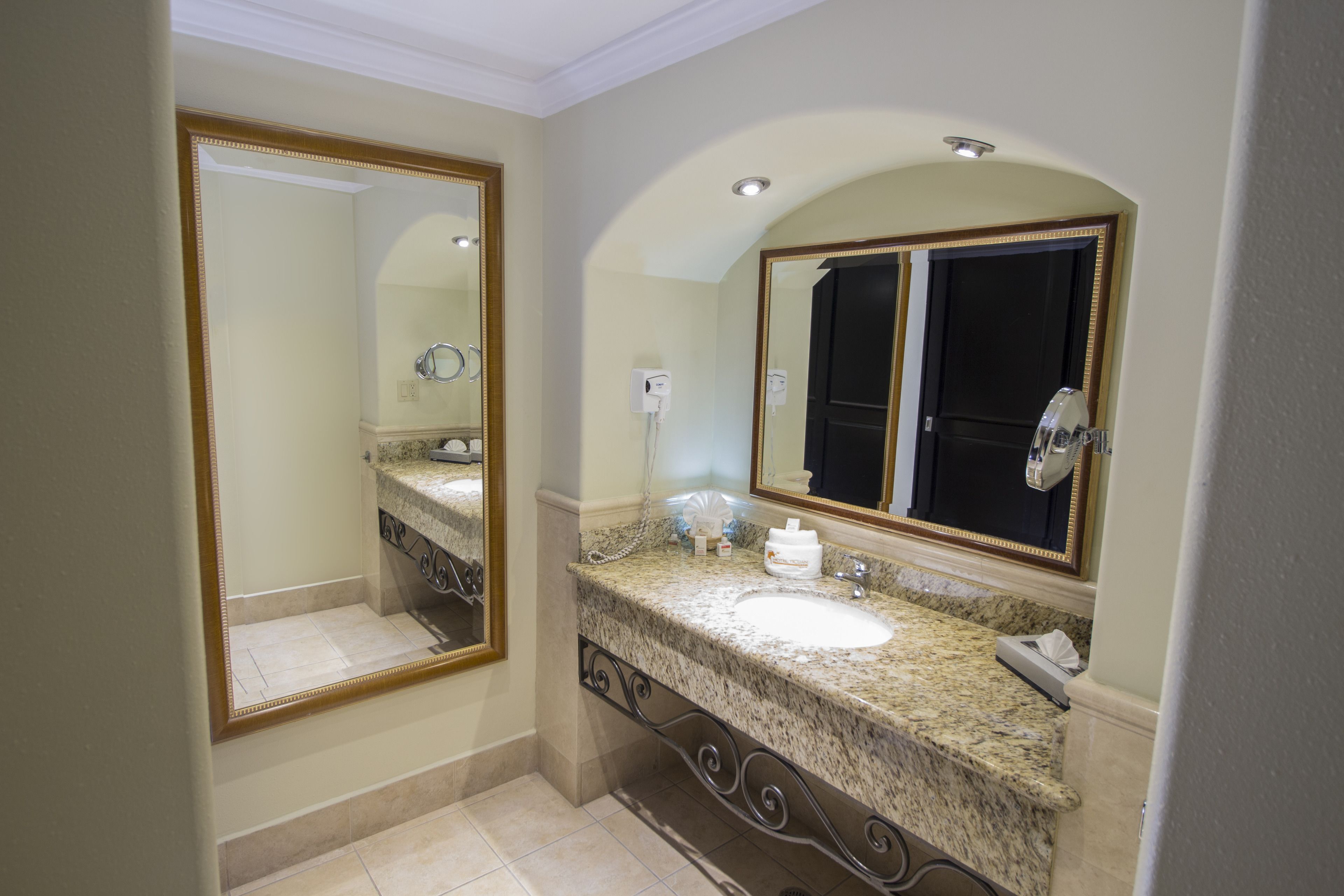 Un baño con un espejo grande, un lavabo y un dispensador de toallas.
