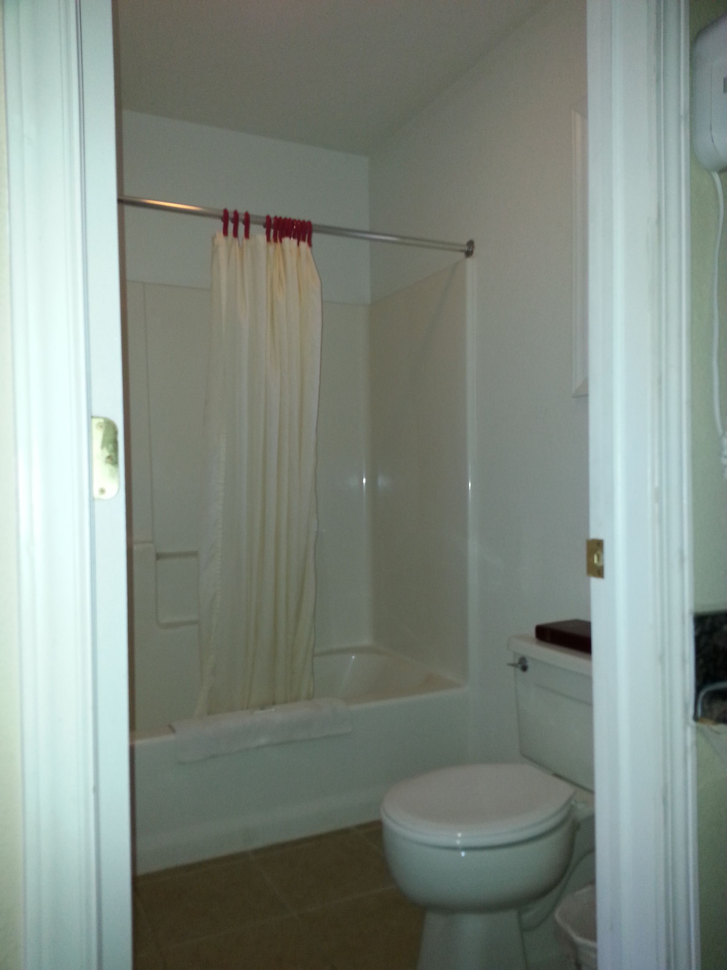 A bathroom with a shower, toilet, and a bathtub.