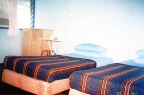 A room with two beds, a wooden dresser, and a small table. - ET Budget Guest House (George Town)