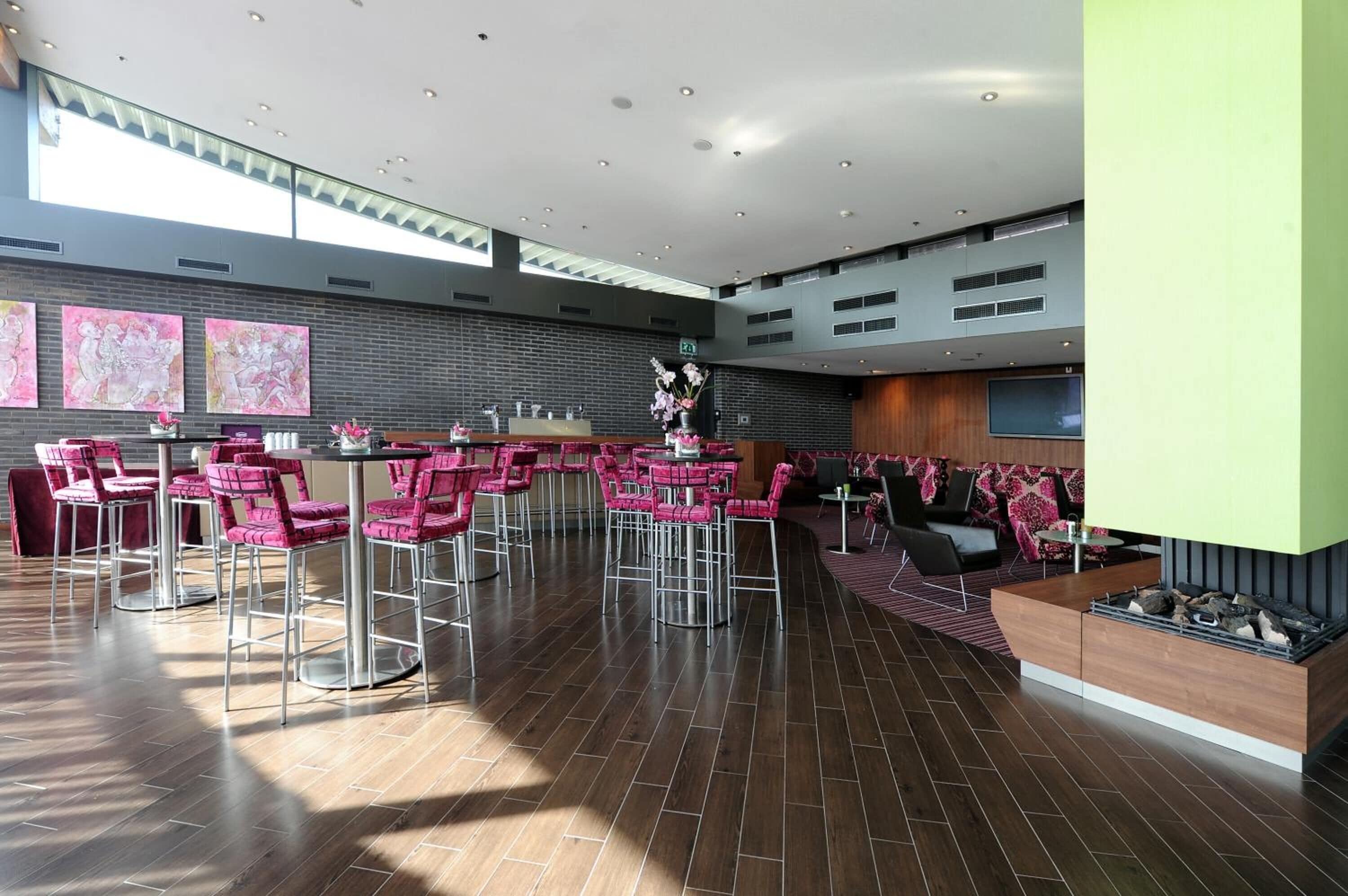 Een ruime lobby met een modern ontwerp, met een bar, zitgedeeltes en kunstwerken aan de wanden.