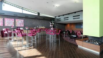 Een ruime lobby met een modern ontwerp, met een bar, zitgedeeltes en kunstwerken aan de wanden.