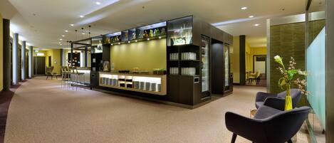 Un vestíbulo de hotel con mostrador de recepción, zona de estar y una decoración de diseño moderno.