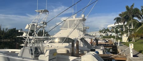 Un port de plaisance où est amarré un grand yacht, avec une cabine, un pont et un treuil bien visible.