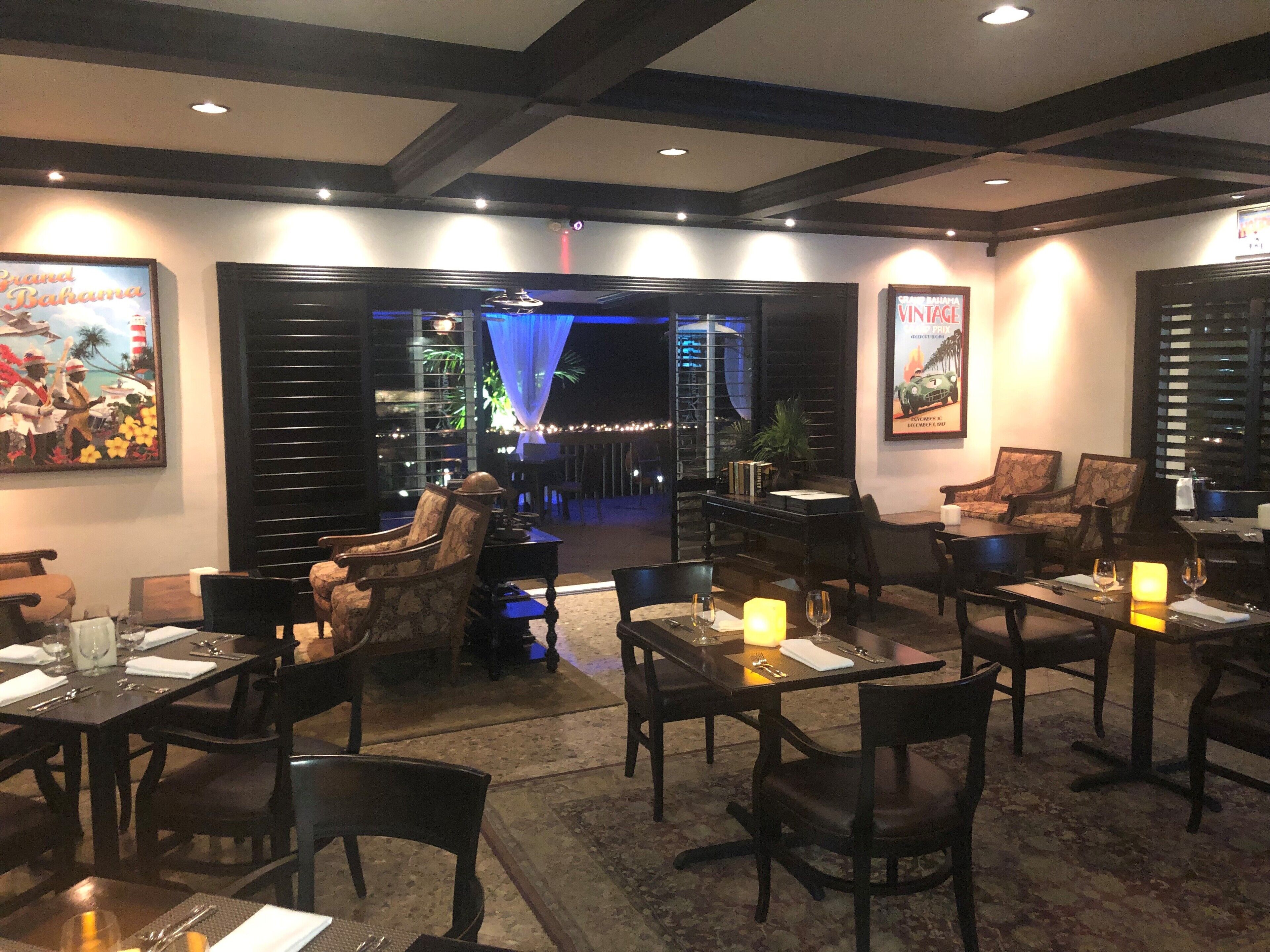 Un ristorante con tavoli e sedie, un'area bar e vista all'esterno.