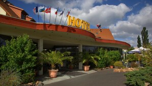 Un hotel con un tetto curvo e diverse bandiere.
