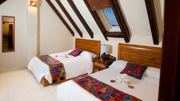 Une chambre avec deux lits, des têtes de lit en bois, un puits de lumière et une petite table de chevet avec une lampe.