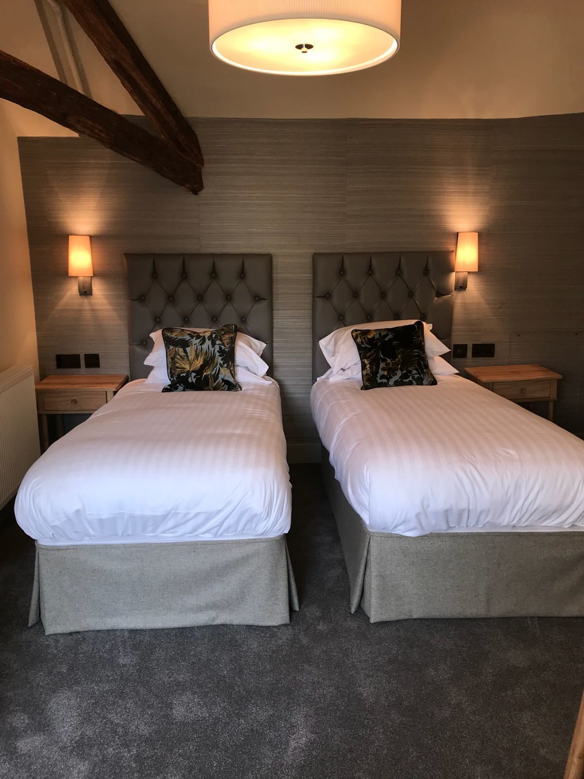 A double room with two beds, each with a headboard and bedside lamps.