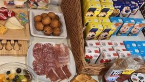 Un bufé de desayuno con una variedad de alimentos, incluyendo pasteles, frutas, quesos y bebidas.