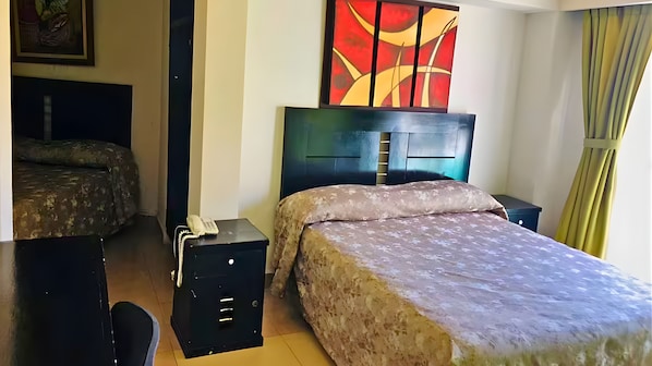 Una habitación de hotel con cama, mesita de noche y teléfono.