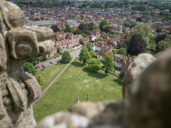 Une ville qui possède des bâtiments historiques, un espace vert central et une statue en premier plan.
