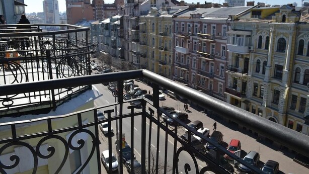 A cityscape with historic buildings, a busy street, and a metal railing. - Heart Kiev Apartments (Kyiv)