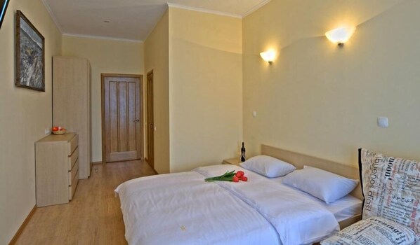 A hotel room with a bed, a nightstand, a dresser, and a door. - Heart Kiev Apartments (Kyiv)
