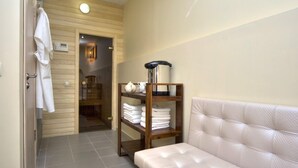 A bathroom with a white bathtub, a wooden shelf with towels, and a white bench. - Golden Gate Inn (Kyiv)