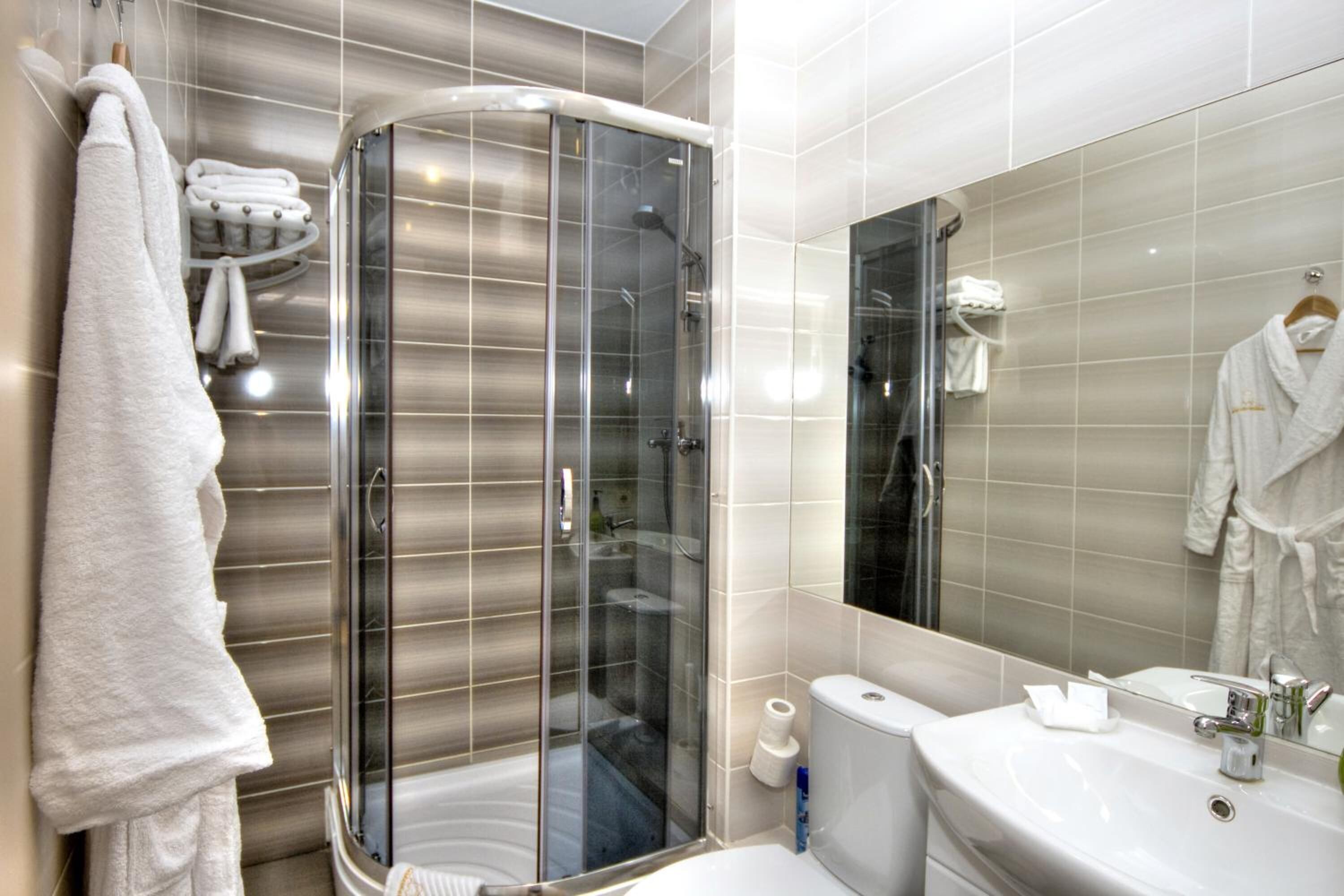A modern bathroom with a glass-enclosed shower, a sink, and a mirror.