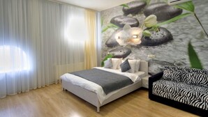 A bedroom with a bed, a sofa, and a mural of stones and flowers. - Golden Gate Inn (Kyiv)