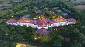 An aerial view of a large, multi-story hotel with a symmetrical facade, surrounded by lush greenery and a swimming pool. - Amazing Bagan Resort (Nyaung-U)