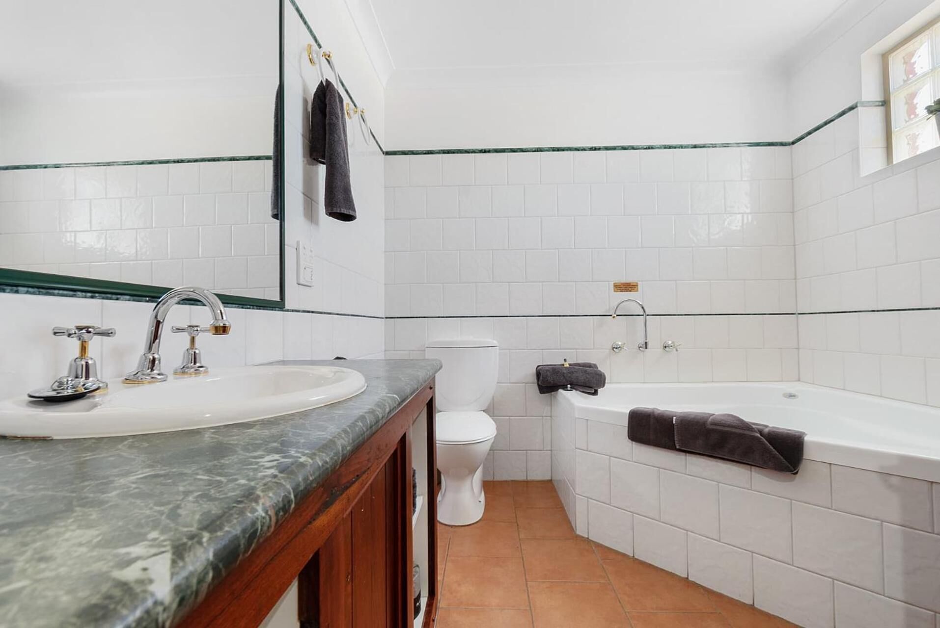 Un baño con lavamanos, inodoro y bañera.