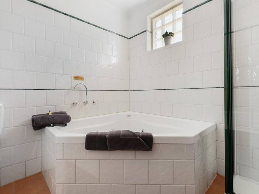 Een badkamer met een bad, toilet en een douchecabine van glas.