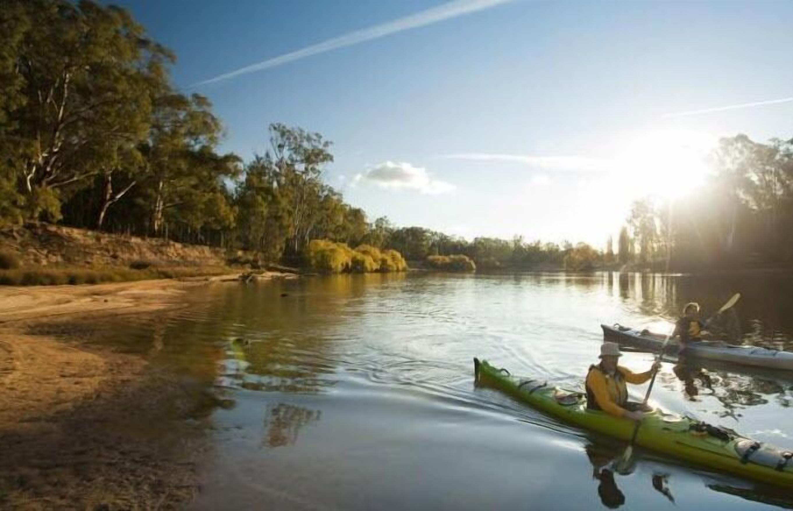 Une rivière paisible où l’on peut faire du kayak, et où une personne est en train de pagayer.