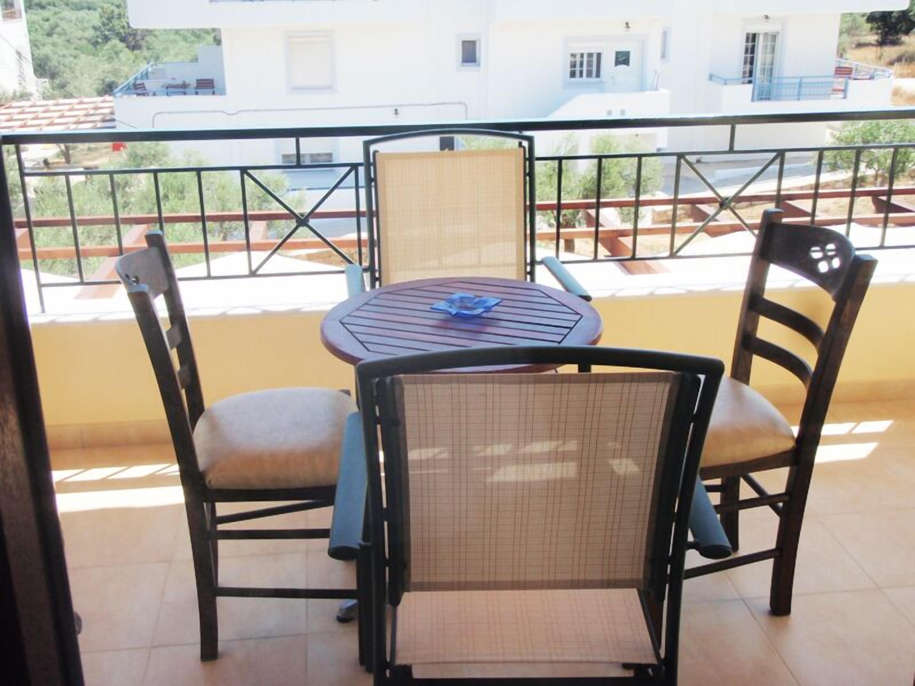 A balcony with a round table and four chairs.