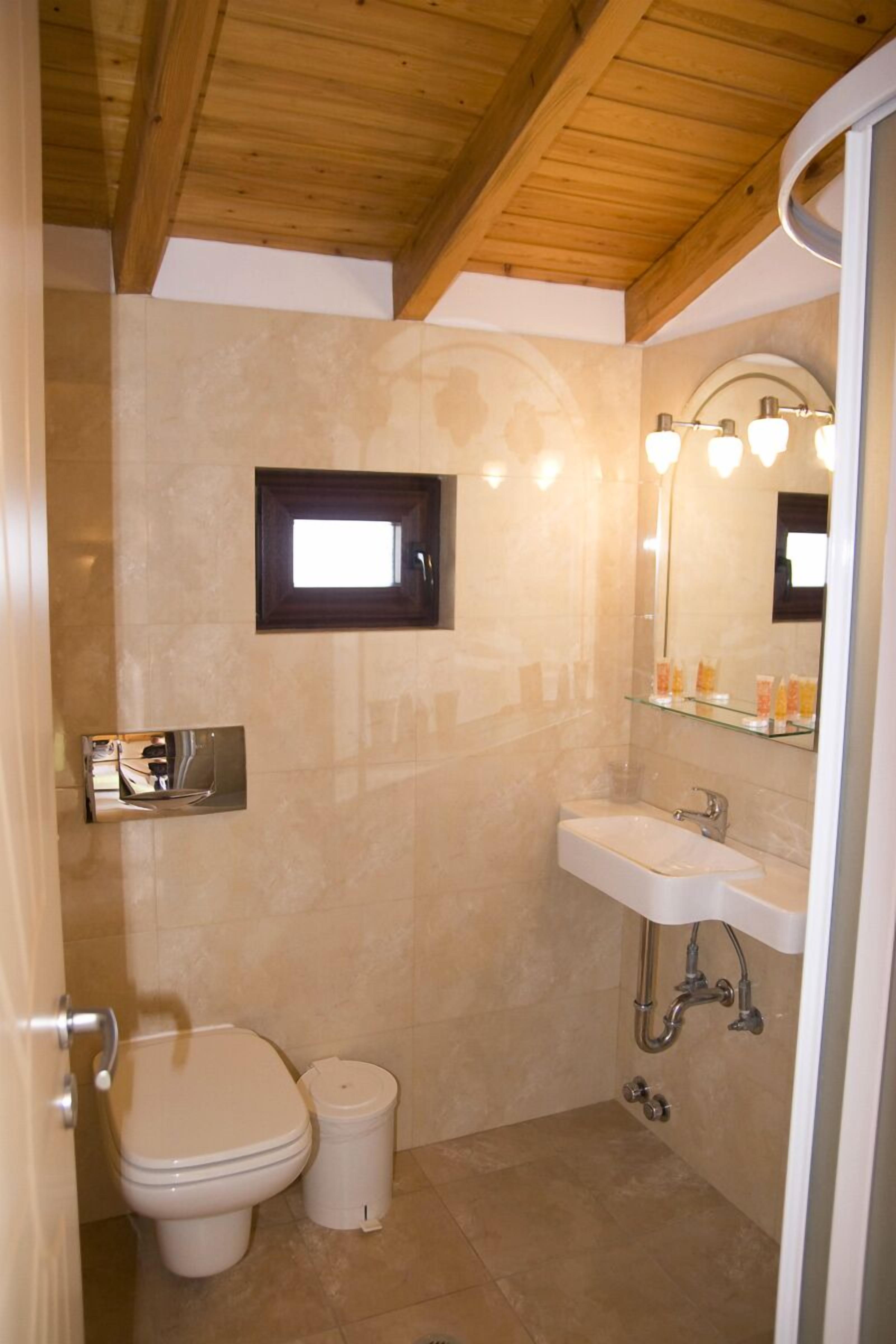Un baño con inodoro, lavamanos y espejo.