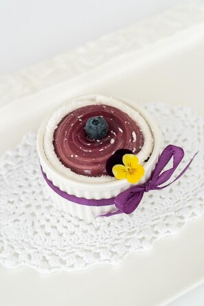 A dessert on a white plate with a lace doily underneath.
