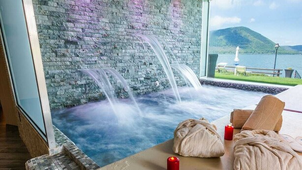 A spa area with a hot tub, towels, and candles. - Relais Sans Souci and Spa (Ronciglione)
