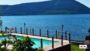 A pool area with a view of a lake and a mountain. - Relais Sans Souci and Spa (Ronciglione)