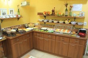 A buffet setup with various food items and utensils.