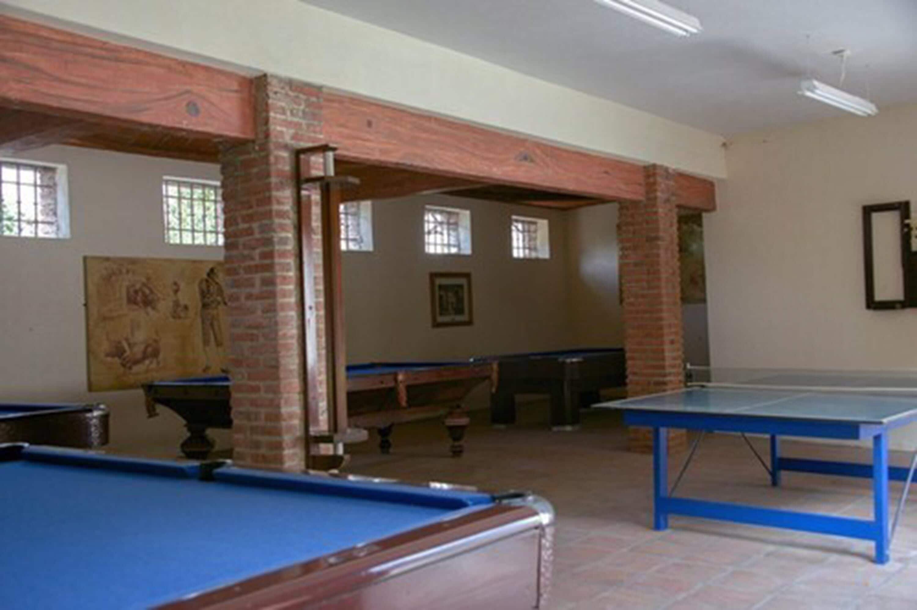 A pool table room with a billiards table, a pool table, and a ping pong table.