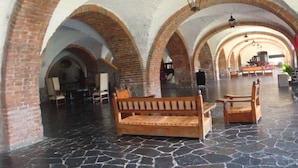 A spacious hall with arched brick ceilings and stone flooring, featuring wooden benches and tables. - Hotel Hacienda Vista Hermosa (Puente de Ixtla)