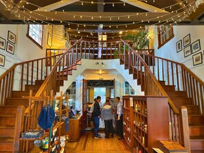 Una escalera de madera con vista al interior, que incluye un espacio de escritorio con varios objetos y una estantería.