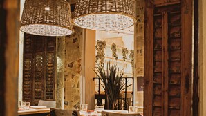 A dining area with wicker lamps, wooden furniture, and a view of the street. - Room Chueca (Madrid)