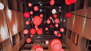 A hotel interior with a central atrium, multiple floors, and a modern chandelier design. - Room Chueca (Madrid)