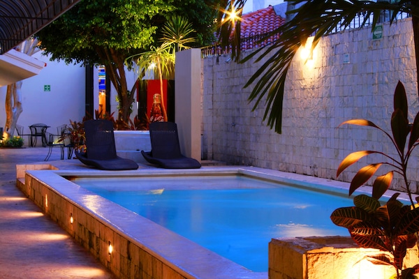 Una piscina al aire libre, sillones reclinables de piscina