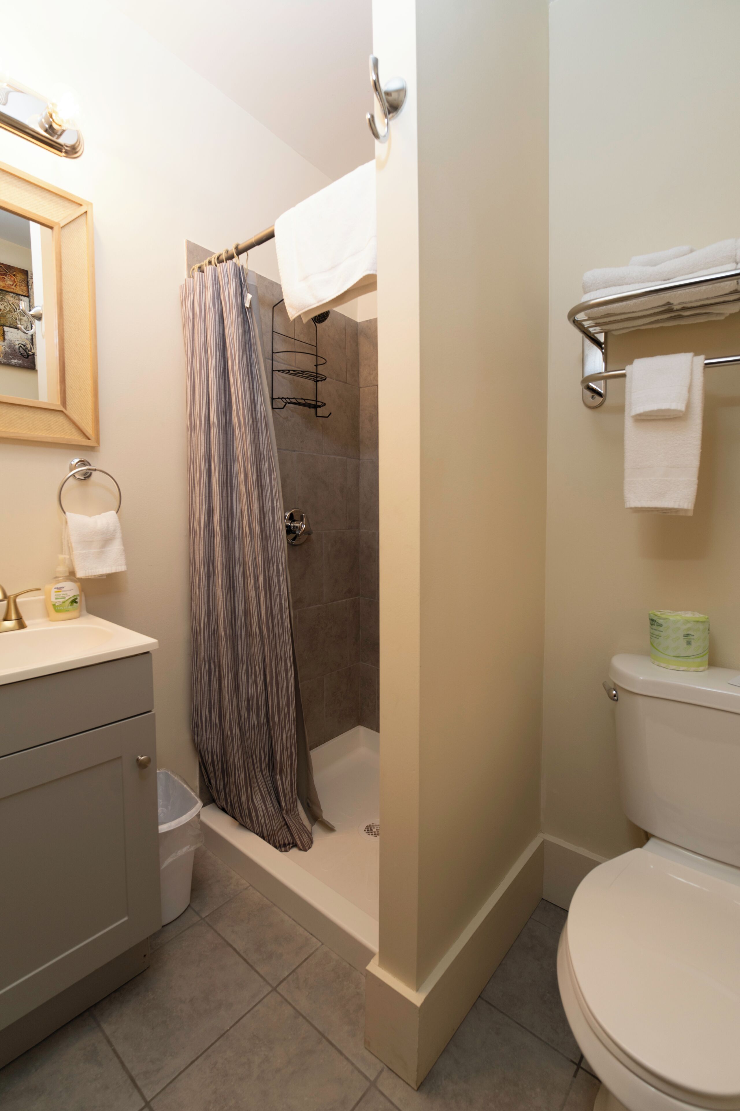 Une salle de bain équipée d’une douche, de toilettes, d’un lavabo et d’un porte-serviettes.