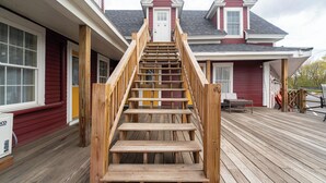 A wooden staircase leading to a house's front door. - The Whitetail and Suites (Lincoln)