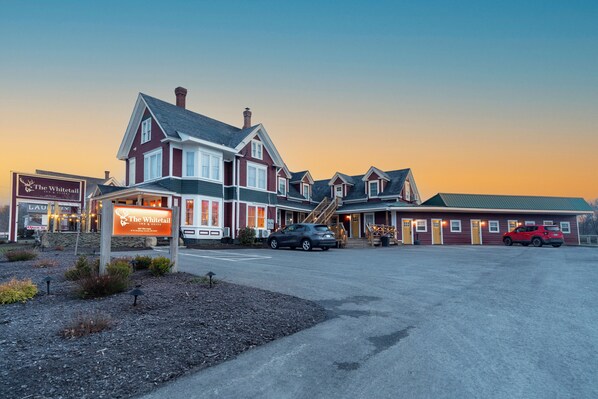 A building with a prominent sign for 'The Whitetail' and a parking lot with cars.