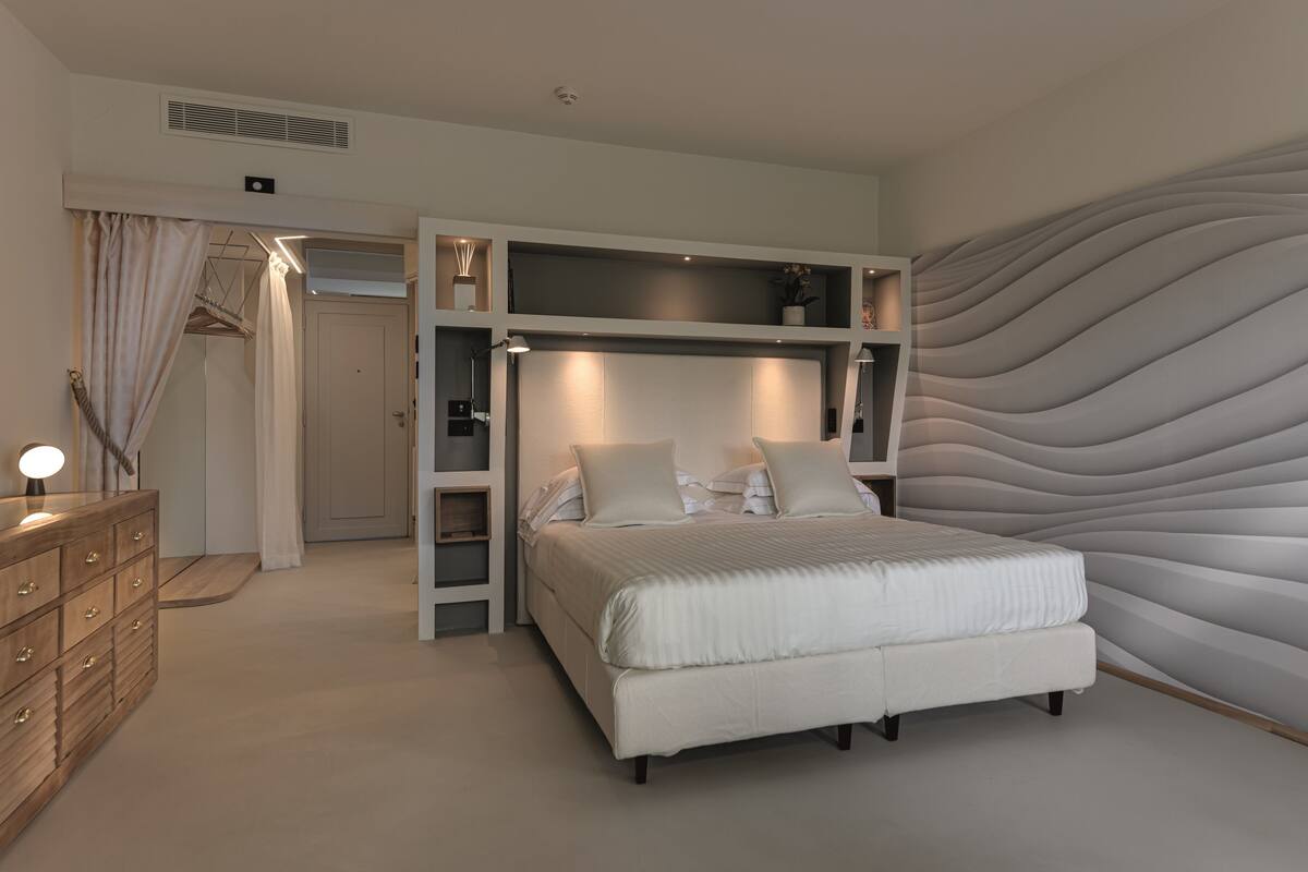 Une chambre à coucher moderne avec un grand lit, des étagères intégrées et un mur au revêtement original.