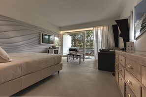 A modern hotel room with a large bed, a desk, and a dining area with a view of the outdoors. - Augustus Hotel & Resort (Forte dei Marmi)